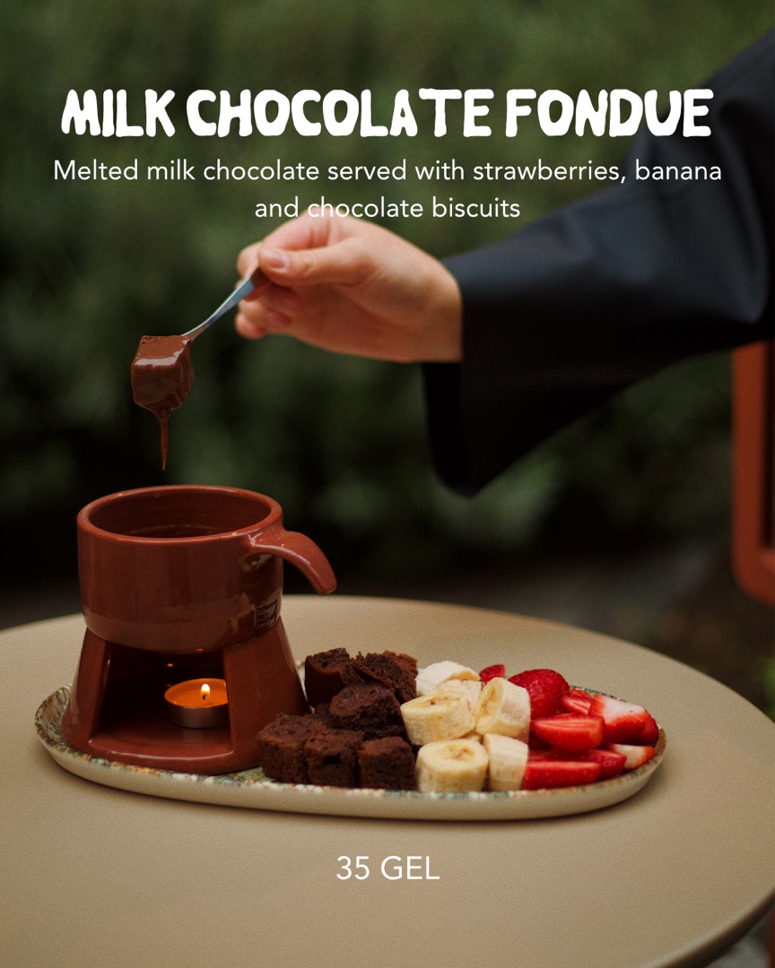 Milk chocolate fondue with strawberries, banana and chocolate biscuits