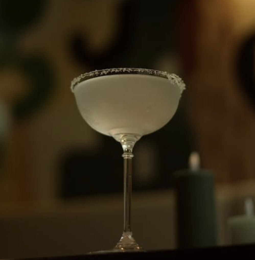Salt-rimmed cocktail in candlelight
