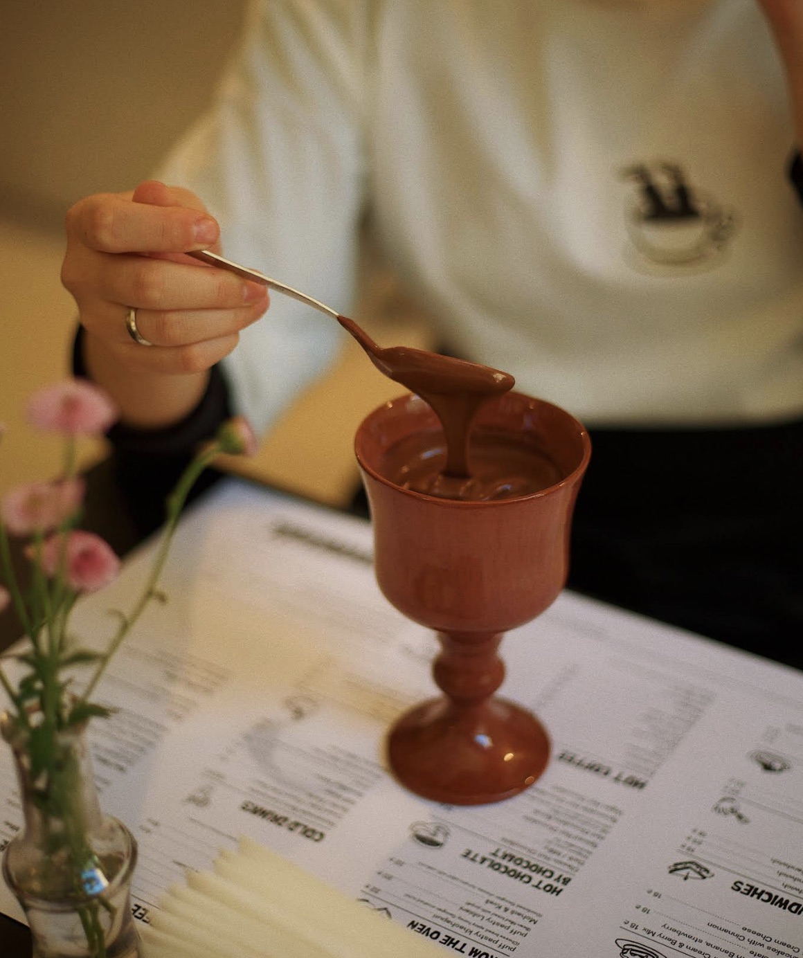 Spoon lifting thick hot chocolate from a cup