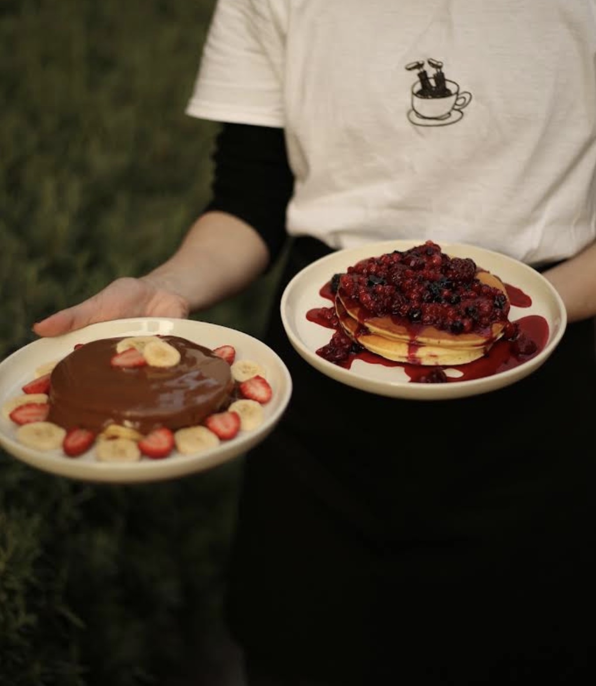 Two plates of pancakes — chocolate and mixed berry